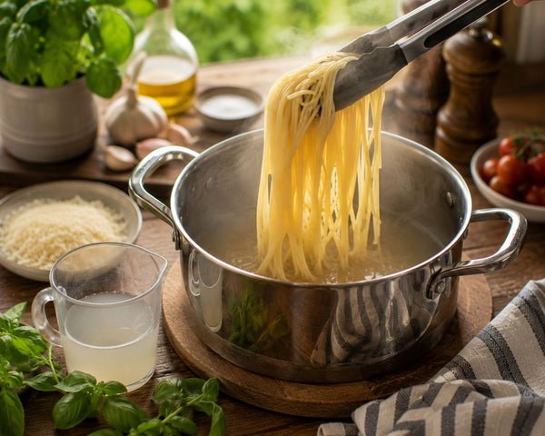 Perfekt kokt spaghetti lyfts ur kastrullen