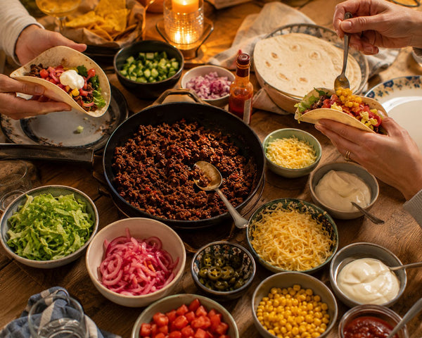 Tacobygge med kryddig färs, tortillabröd, picklad rödlök och färska tillbehör på bord